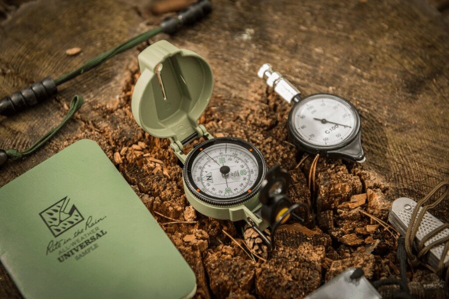 Kompas Ranger MK2 Helikon-Tex® és egy strapabíró jegyzetfüzet tuskón a természetbeni tájékozódáshoz. Fotó: Helikon-Tex, Rigad