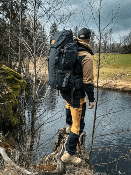 Fjällräven outdoor nadrág és hátizsák a folyóparton a természetben. Fotó: Rigad