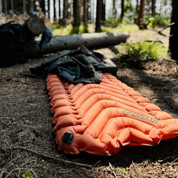 Szigetelt felfújható matrac Static V™ Klymit<sup>®</sup> narancssárga az erdőben. Fotó: Rigad