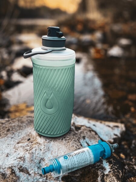 Flux™ HydraPak® összecsukható palack HydraPak® vízszűrővel (28 mm), kőre helyezve a patak mellett. Foto: Rigad