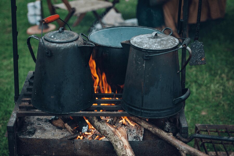 Vízforraló és üst a grillsütő rostélyán kempingezés közben. Forrás: https://www.pexels.com/cs-cz/foto/221436/
