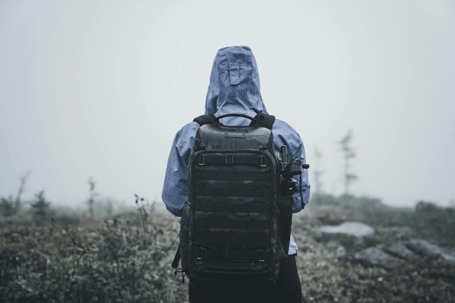 Vízálló kabátos ember a fagyos tájon. Forrás: https://www.pexels.com/cs-cz/foto/priroda-muz-kmeny-chytry-telefon-5048614/