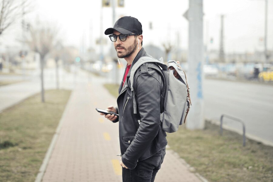 Egy férfi az utcán hátizsákkal és mobiltelefonnal. Forrás: https://www.pexels.com/cs-cz/foto/845457/
