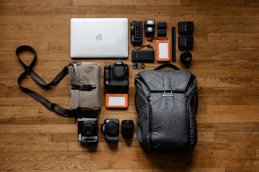Kicsomagolt hátizsák fényképezőgépekkel és elektronikával. Forrás: https://www.pexels.com/cs-cz/foto/apple-jablko-chytry-telefon-notebook-3178938/