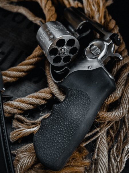 Modern revolver részlete üres, kihajtott forgódobbal és fekete gumi markolattal.