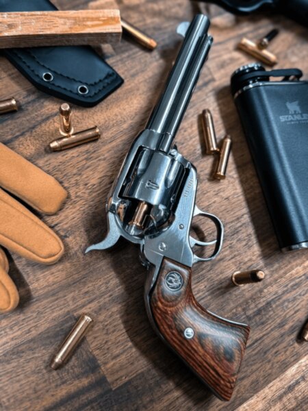 A Ruger egyetlen akciós revolvere hosszú csővel és fa markolattal a lőszerek és a szabadtéri felszerelések között.