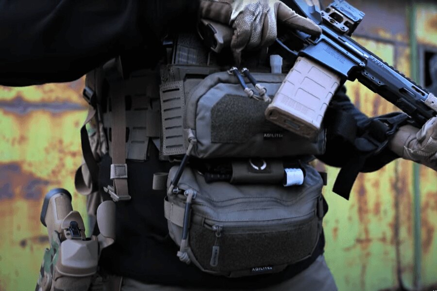 Férfi Reaper™ Agilite Gear<sup>®</sup> Chest Riggel, amely tele van tölténytartó tasakokkal és hosszú fegyverrel. Forrás: Rigad - video