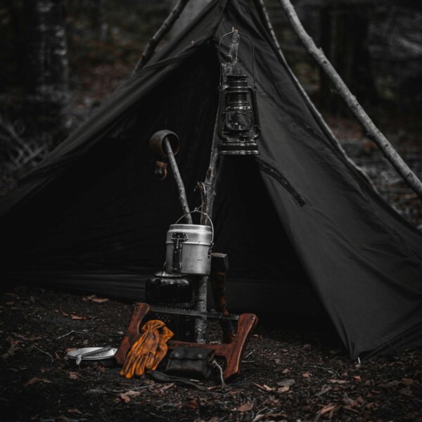 Erdőben lévő bushcraft menedék. Forrás: https://www.pexels.com/cs-cz/foto/les-dobrodruzstvi-kempovani-lampion-14074699/