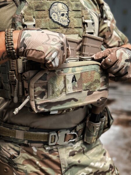 Multicam felszerelésben lévő operátor nyitja meg az Agilite<sup>®</sup> Pincer Admin Panel-t, amely a K-ZERO SF lemez hordozóra van rögzítve, és kezeli a tárakat. Fotó: Rigad
