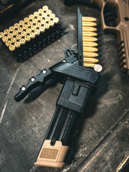 Nine Reloaded tárfeltöltő a 9 mm Luger kaliberű lőszerek és pisztoly mellett.