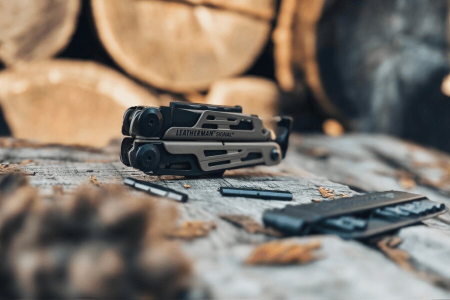 Leatherman Signal fa asztalon elhelyezve, bitjeivel és tartozékaival, szabadtéri környezetben.