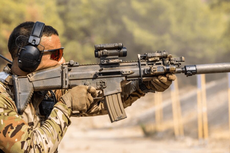 Lövész FN SCAR puskával, kolimátorral, lámpával és hangtompítóval felszerelve.