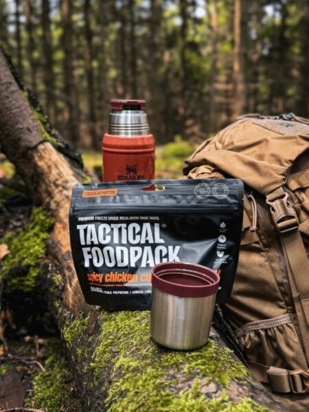 A fagyasztva szárított Tactical Foodpack étel Stanley termosz, bögre és hátizsák az erdőben.