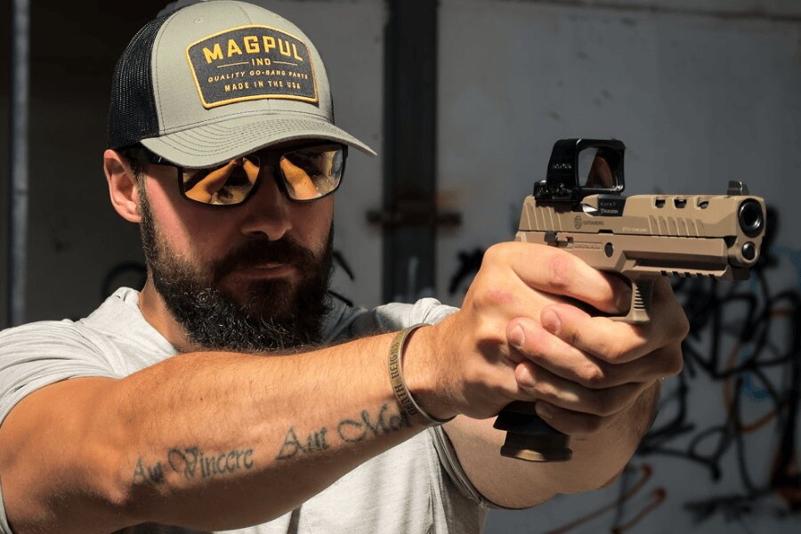 SIG Sauer P320 DH3 pisztollyal célzó, védőszemüveget viselő lövész Holosun irányzékkal.