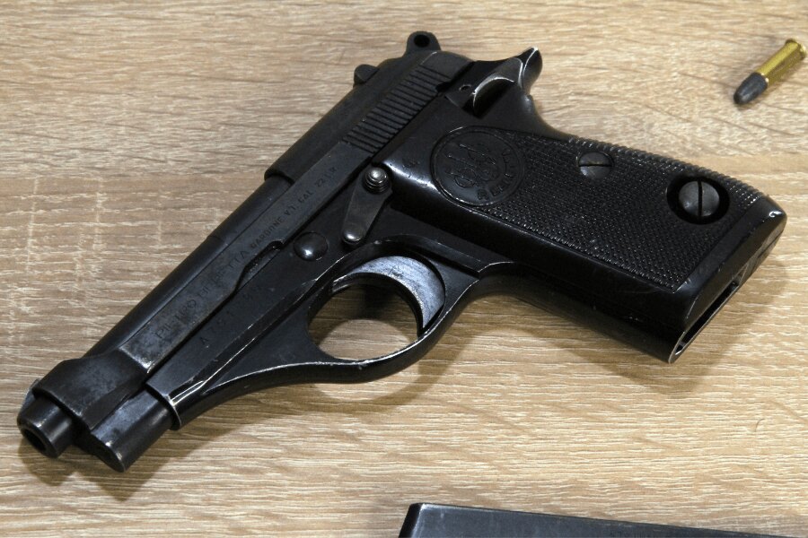 Beretta 71 pisztolyrészlet világos fából készült asztalon.
